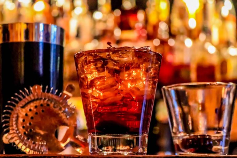 Manhattan cocktail with two other drinks on a bar - Numbing the Pain: Addiction Isn’t a Question of Willpower