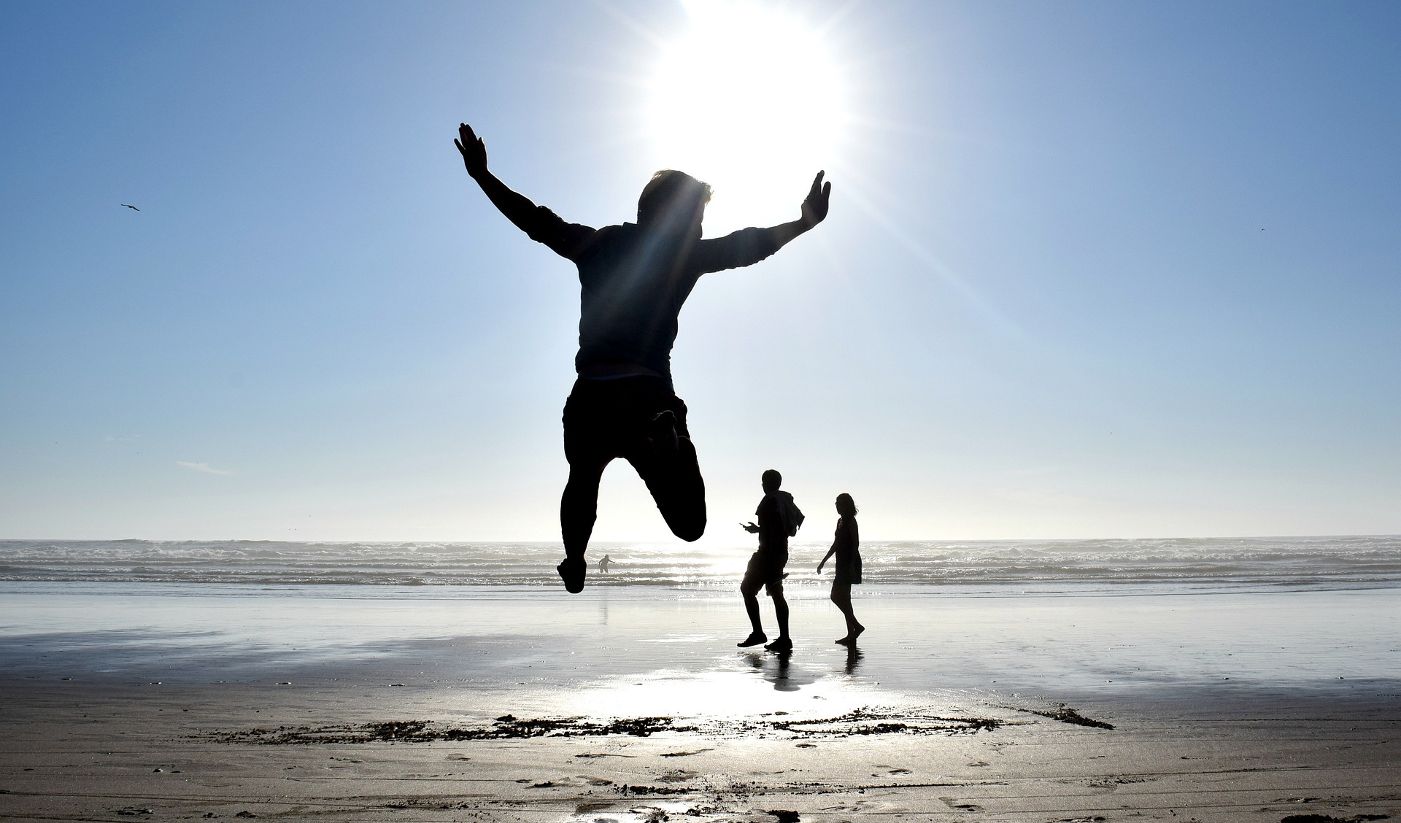 MINDFUL REFLECTIONS: Pain and ignorance give birth to darkness and more 13 Three silhouettes on sunlit beach, including one of boy jumping - Mindfully Letting the Light of the Sun Drown Out Darkness