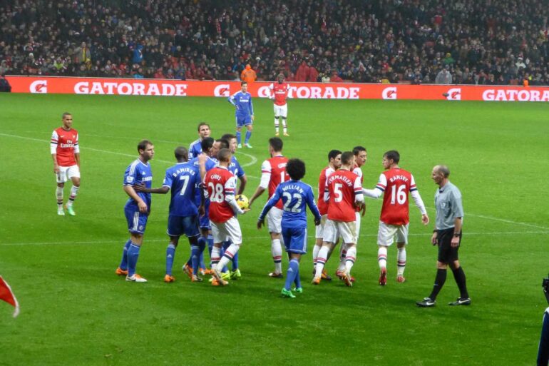 THE ENGLISH DREAM: Finding freedom and vitality as a British football fan 13 Chelsea vs. Arsenal British football game, with red and blue jerseys - Finding Freedom at a Charlie Cooke Football Game
