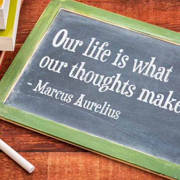 Marcus Aurelius quote on chalkboard next to stack of books - The 5 Best Books on Stoicism for Novice and Longtime Stoics