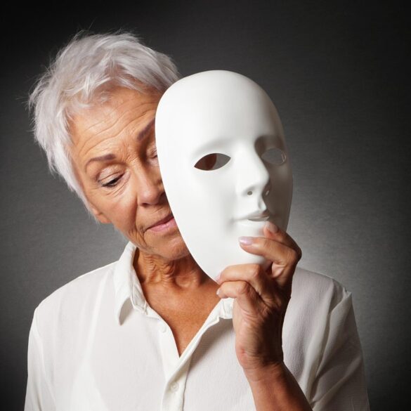 Older woman removing white mask from face - Stoicism Quotes on Death: 11 Quotes From Seneca and Others