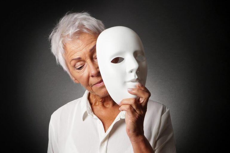 Older woman removing white mask from face - Stoicism Quotes on Death: 11 Quotes From Seneca and Others