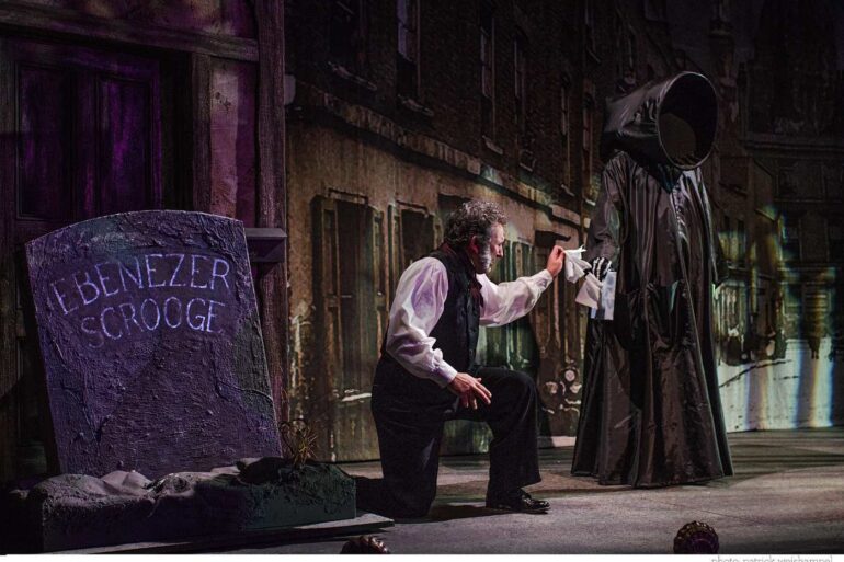 Ebenezer Scrooge and Ghost of Christmas Yet to come next to Scrooge's grave - The True Meaning of Christmas: 4 Popular Stories