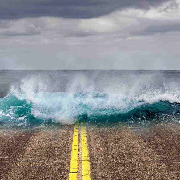 art - woman watching the sea take over a road