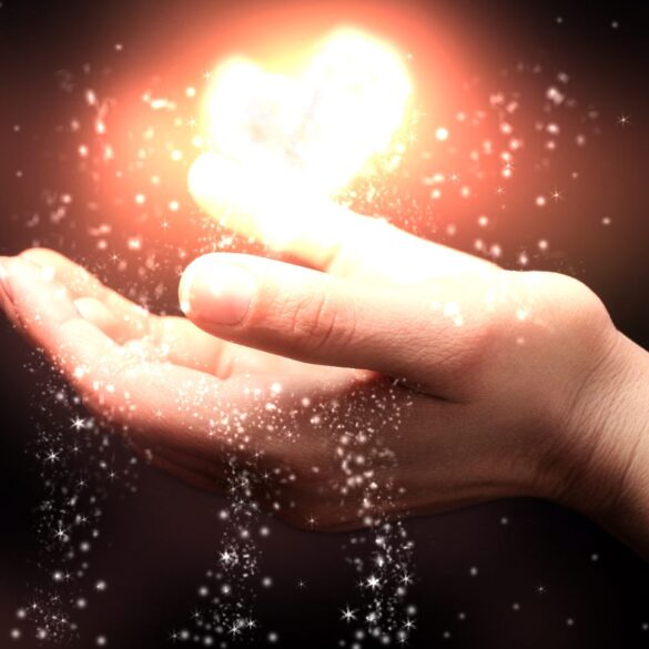Person catching illuminated heart in hand