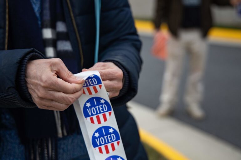 Person with "I VOTED" stickers at 2020 U.S. election polling station - A SENSE OF CARING: 4 responsibilities Americans must uphold