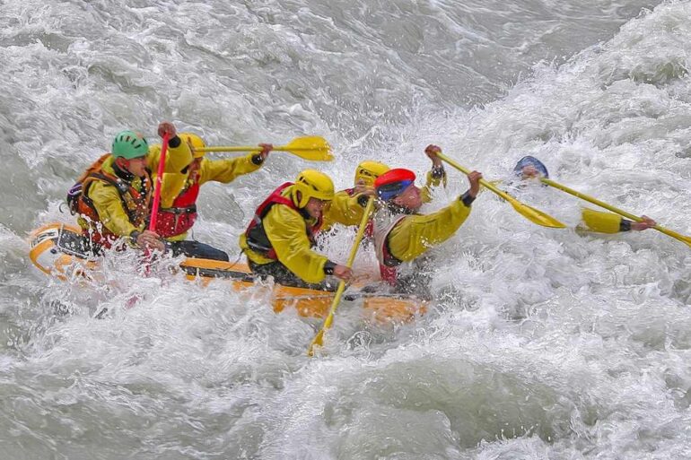 Five people paddling through rapids in raft - Stoicism for Inner Peace: Let the 4 Basic Virtues Guide You