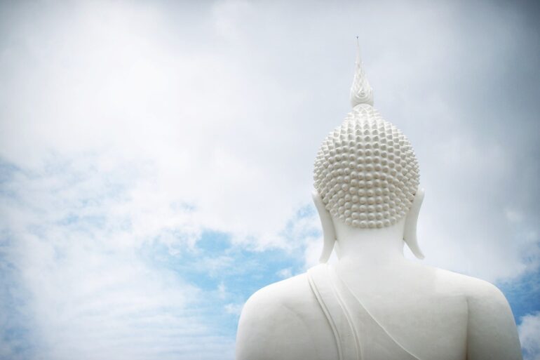 Head of Buddha statue facing clouds - Welcoming Beginner’s Mind: A Helpful Book on Buddhist Wisdom