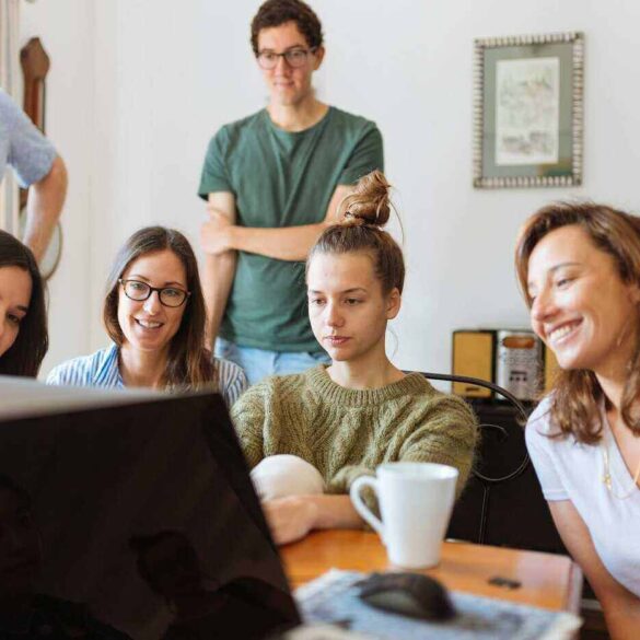students around a table doing a video call together