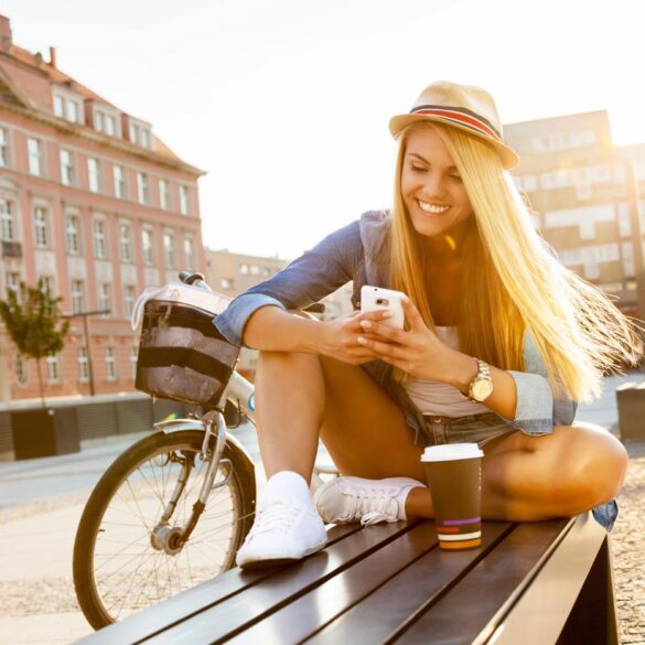 Young woman texting on bench - Crisis of Consciousness: We're Entering a New Paradigm