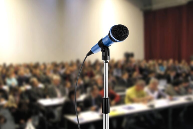 SPEAK-DOWN CULTURE: Can we change our "silent society" at home, school and work? 19 Microphone in front of full lecture hall - Public Speaking: 4 Ways We Can Transform Our Silent Society