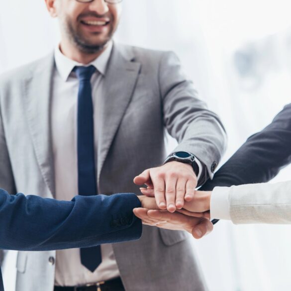 Happy business team stacking hands