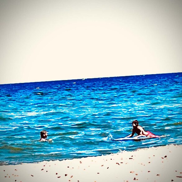 Two kids swimming at a beach - 7 New Poems About Humanity, Including "Support Group"