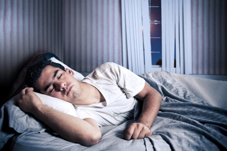 Young man sleeping in bed