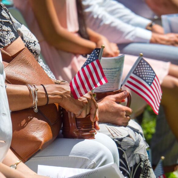 Various people sitting in chairs, holding small American flags - Our Natural Identity: Can It Overpower Political Discord?