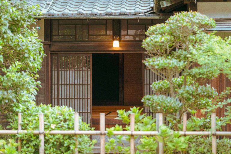 Wooden building with trees and gate in front