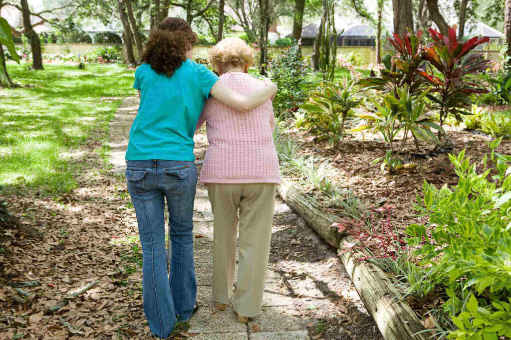 Woman walking with elderly grandmother outdoors