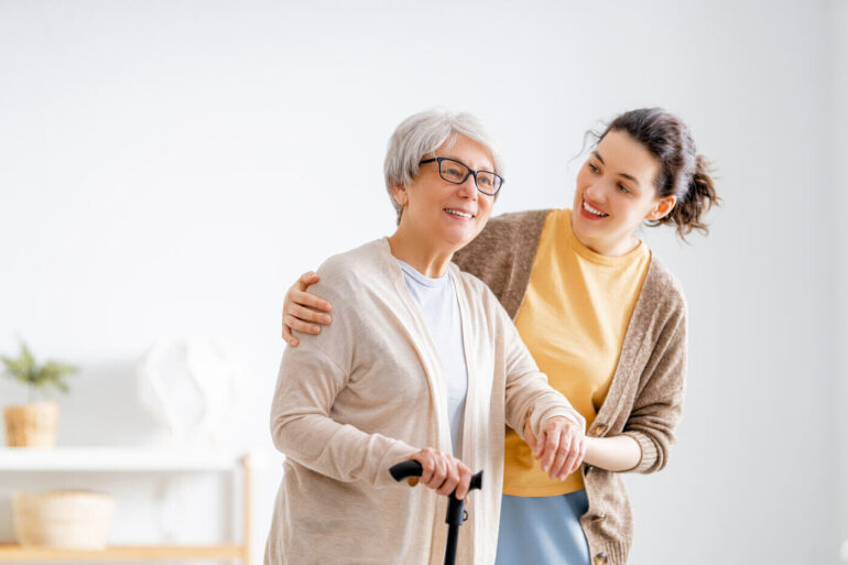 THE HIDDEN TOLL OF CAREGIVING: A mindful approach to psychological well-being 13 Younger woman caring for senior woman with cane - Collective Mindfulness for Caregivers: 6 Uplifting Benefits