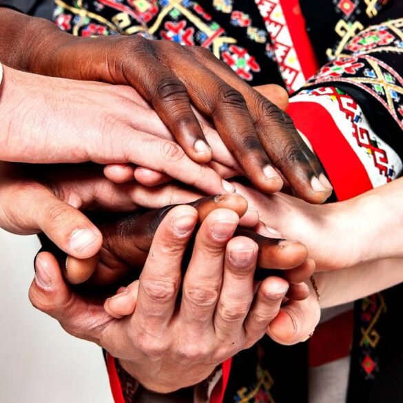 Diverse group of hands on top of each other in solidarity - How Inner Peace Leads to Outer Peace and Stable Communities