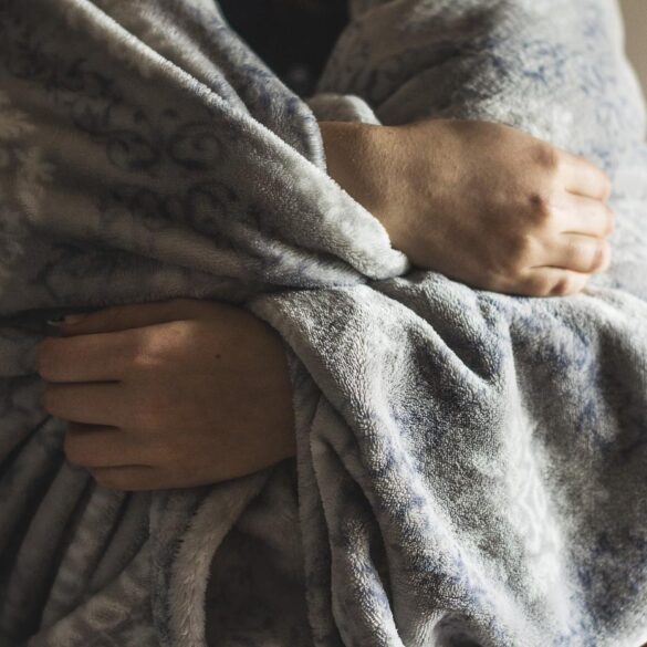 Person wrapped in warm grey blanket - How I Embraced Softness as a Life-Changing Remedy for Fear