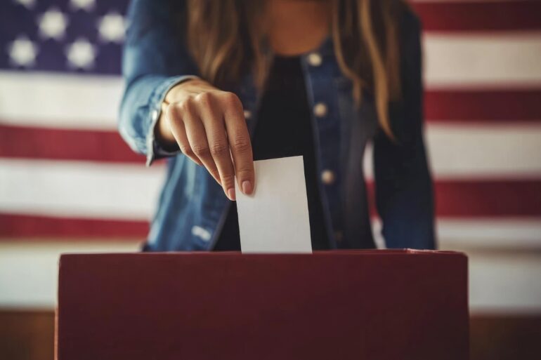 CRUELTY DESTROYS AND COMPASSION HEALS: No sense of caring equals no sense of community 16 Woman putting vote in ballot box with American flag behind her - Compassion Heals: How Mindfulness Can Help Direct America