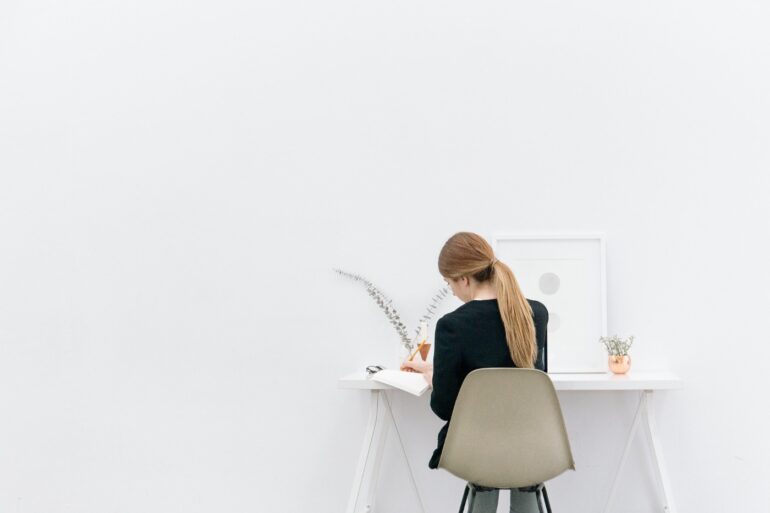 Woman writing in notebook at desk - Sehnsucht: An Inexplicable Yearning When Life Seems Fine