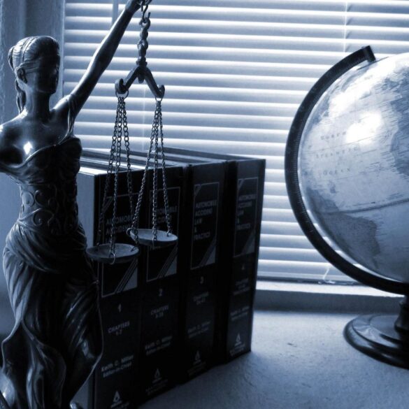 Lady Justice statue next to legal books and globe - The Gift of Privilege: What Does This Really Mean?