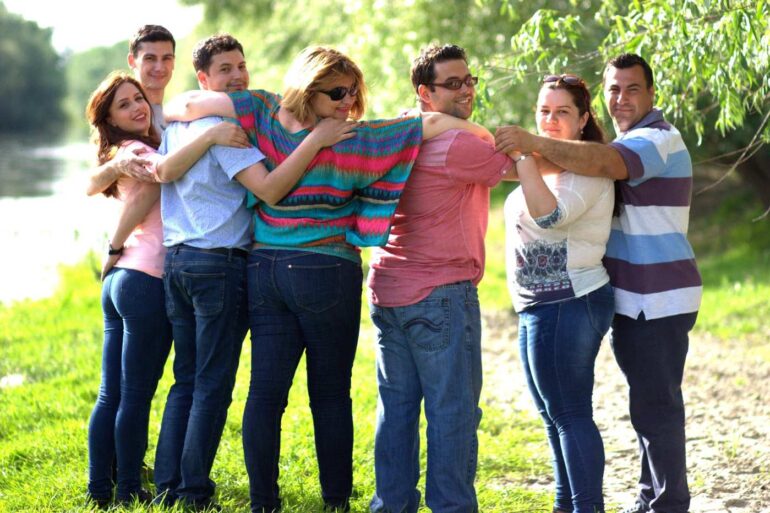 Group of Millennial friends with arms around each other at park - Millennials: 3 Big Questions They’re Asking Themselves