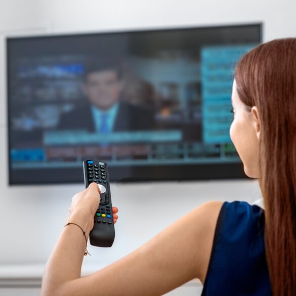 Young woman watching news on TV - The 24-Hour News Cycle: How Stoicism Can Help Us Survive It