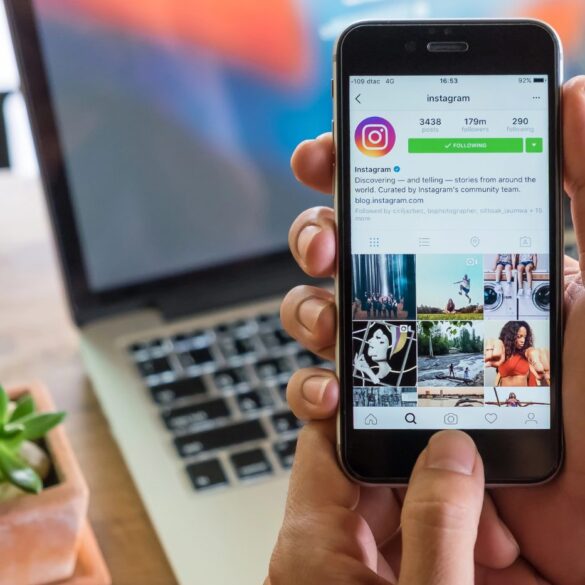 Instagram app open on a person's phone, next to a laptop - 10 Ways Leaving Social Media Helps You Life Your Best Life