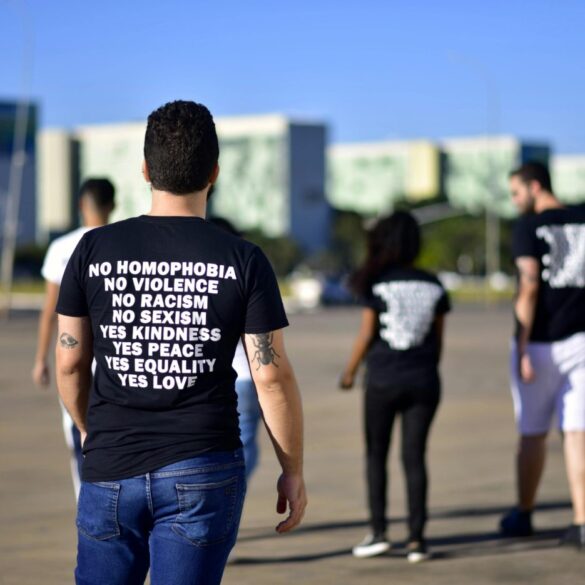 Man wearing t-shirt with "no homophobia, no violence" and other positive phrases - 10 Mindful Living Tips Inspired by the Dalai Lama