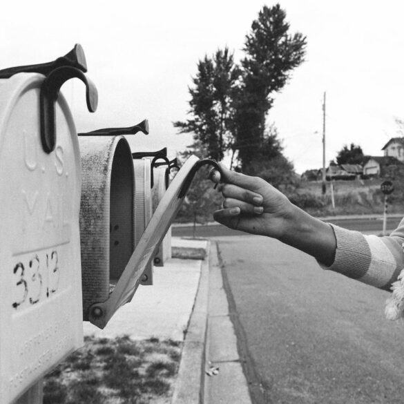 Woman opening mailbox on suburban street - The Language of Grief: Creating a New Life After Loss
