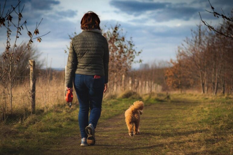 THE BEAUTY OF A QUIET MIND: How quieting the mind awakens intuition and compassion 15 Woman walking dog off-leash down outdoor path - How a Quiet Mind Awakens Intuition and Compassion