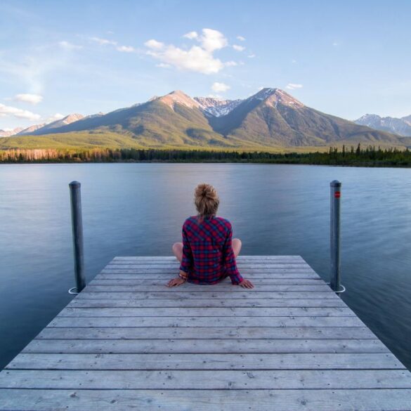 Woman sitting on dock by water, relaxing - Hello 2026: Time to Slow Down and Reflect