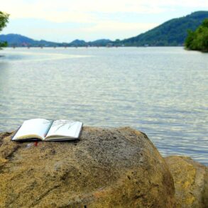 Writing notebook on rock next to river - From Confusion to Clarity: 3 More Stages on a Spiritual Path