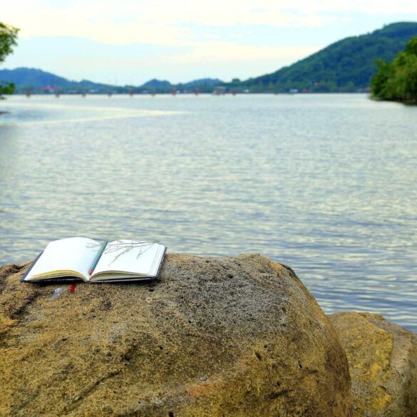 Writing notebook on rock next to river - From Confusion to Clarity: 3 More Stages on a Spiritual Path