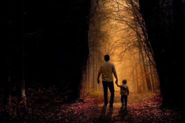 Father and son walking on sunlit path through dark woods - 5 Fun and Playful Ways to Help Children Explore Mindfulness