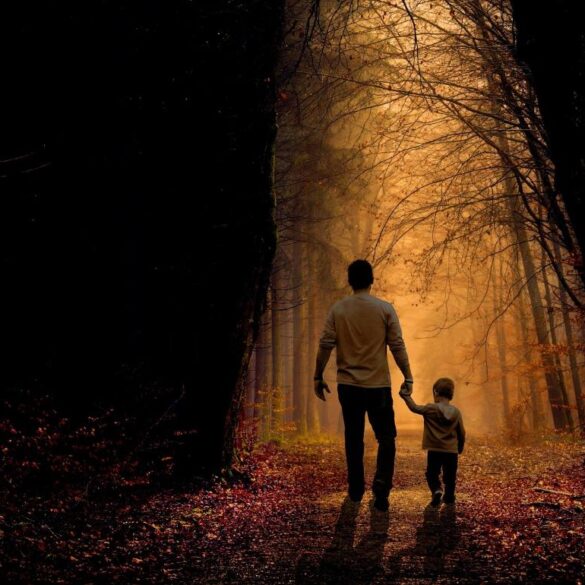 Father and son walking on sunlit path through dark woods - 5 Fun and Playful Ways to Help Children Explore Mindfulness