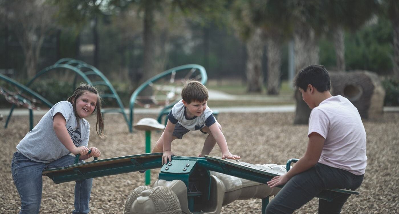 Three kids playing on playground equipment - How Social and Emotional Learning Helps Kids Succeed