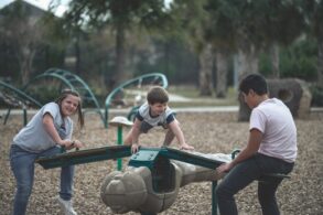 Three kids playing on playground equipment - How Social and Emotional Learning Helps Kids Succeed