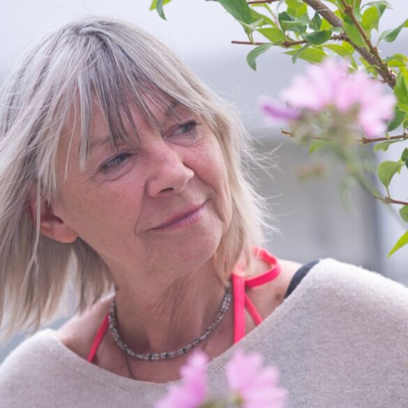 Senior woman reaching out and peacefully touching plant - Try a Simple 3 Moments of Joy Exercise to Cultivate Optimism
