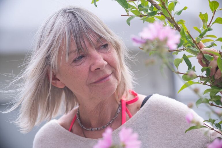 FIND JOY THROUGH MINDFULNESS: The hidden power of optimism 14 Senior woman reaching out and peacefully touching plant - Try a Simple 3 Moments of Joy Exercise to Cultivate Optimism