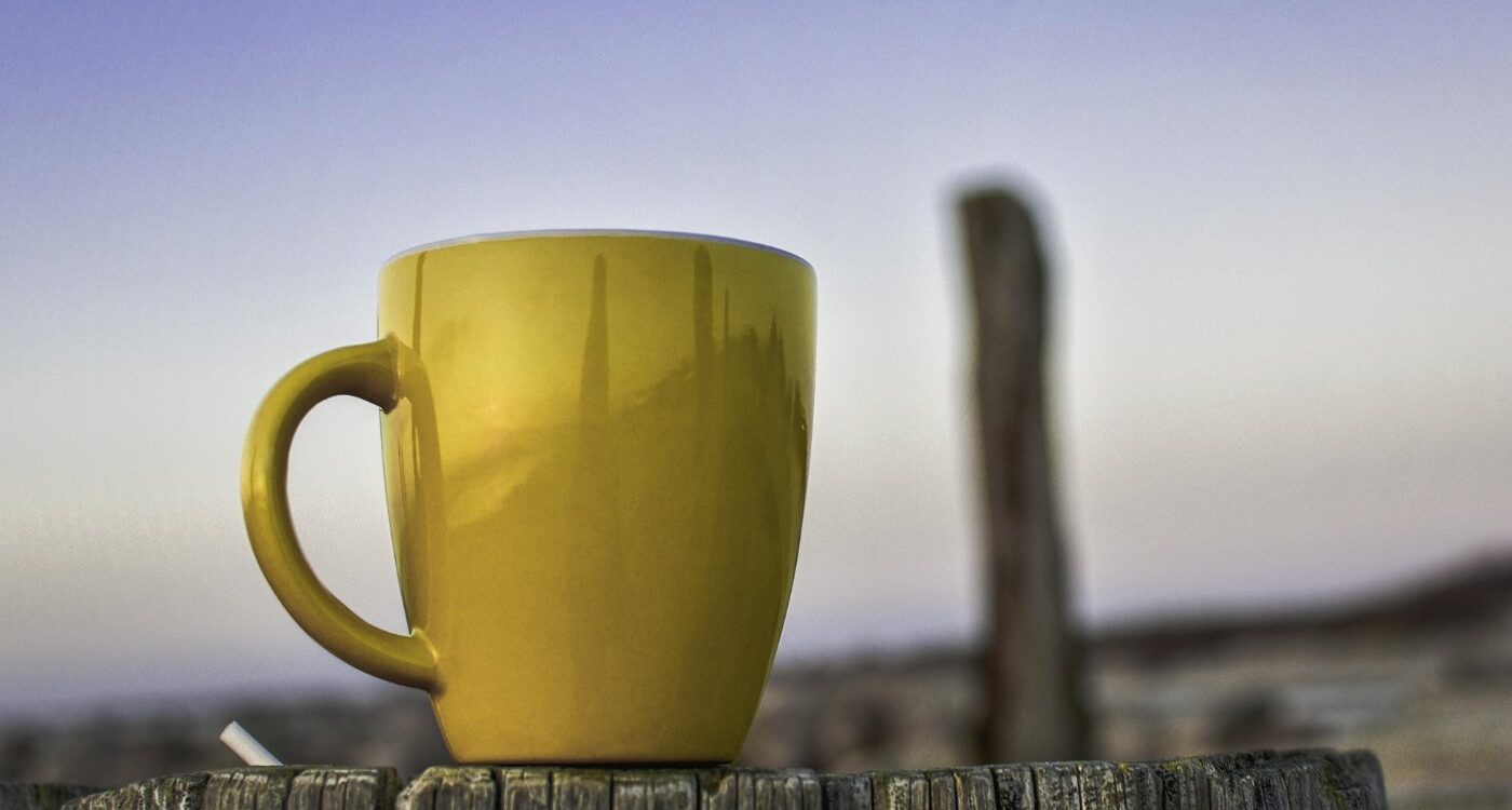 Cup of tea on fence outdoors with blue sky in background - Gratitude for Ordinary Life: Find Beauty in Everyday Moments