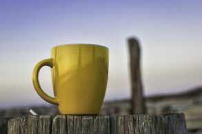 Cup of tea on fence outdoors with blue sky in background - Gratitude for Ordinary Life: Find Beauty in Everyday Moments