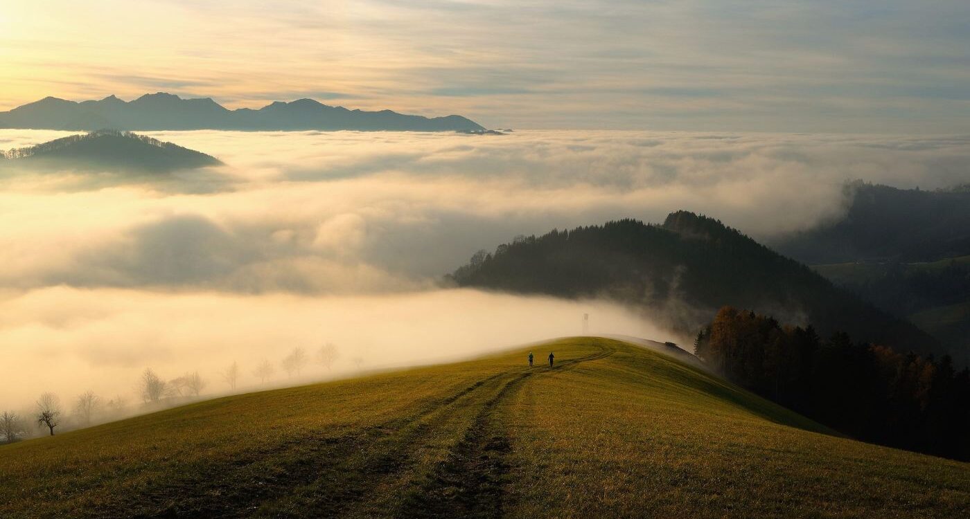 Two people seen at a distance walking towards misty mountains - Why I Decided to Stop Making Myself Smaller in Relationships