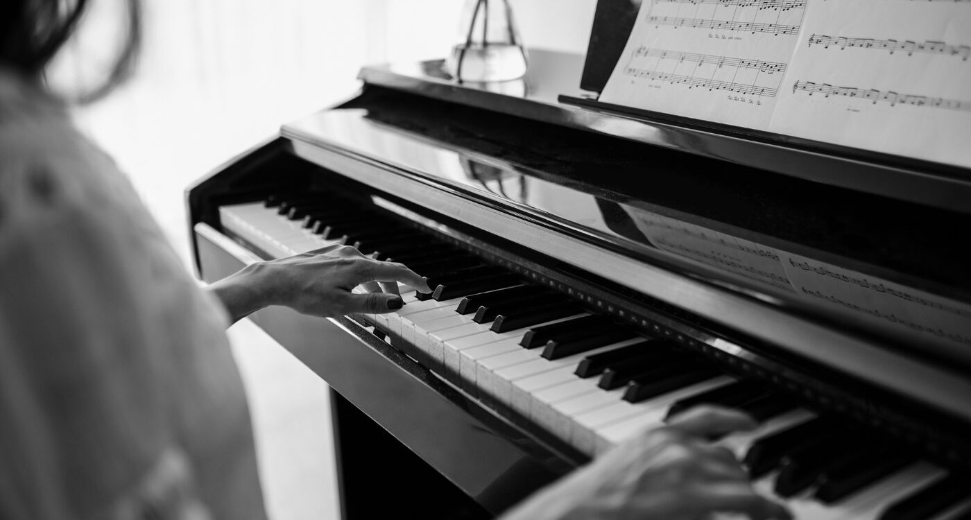 Black and white image of woman playing piano - Your Piano Is Patiently Waiting for You—Go Play!