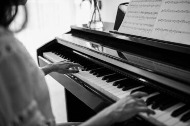 Black and white image of woman playing piano - Your Piano Is Patiently Waiting for You—Go Play!