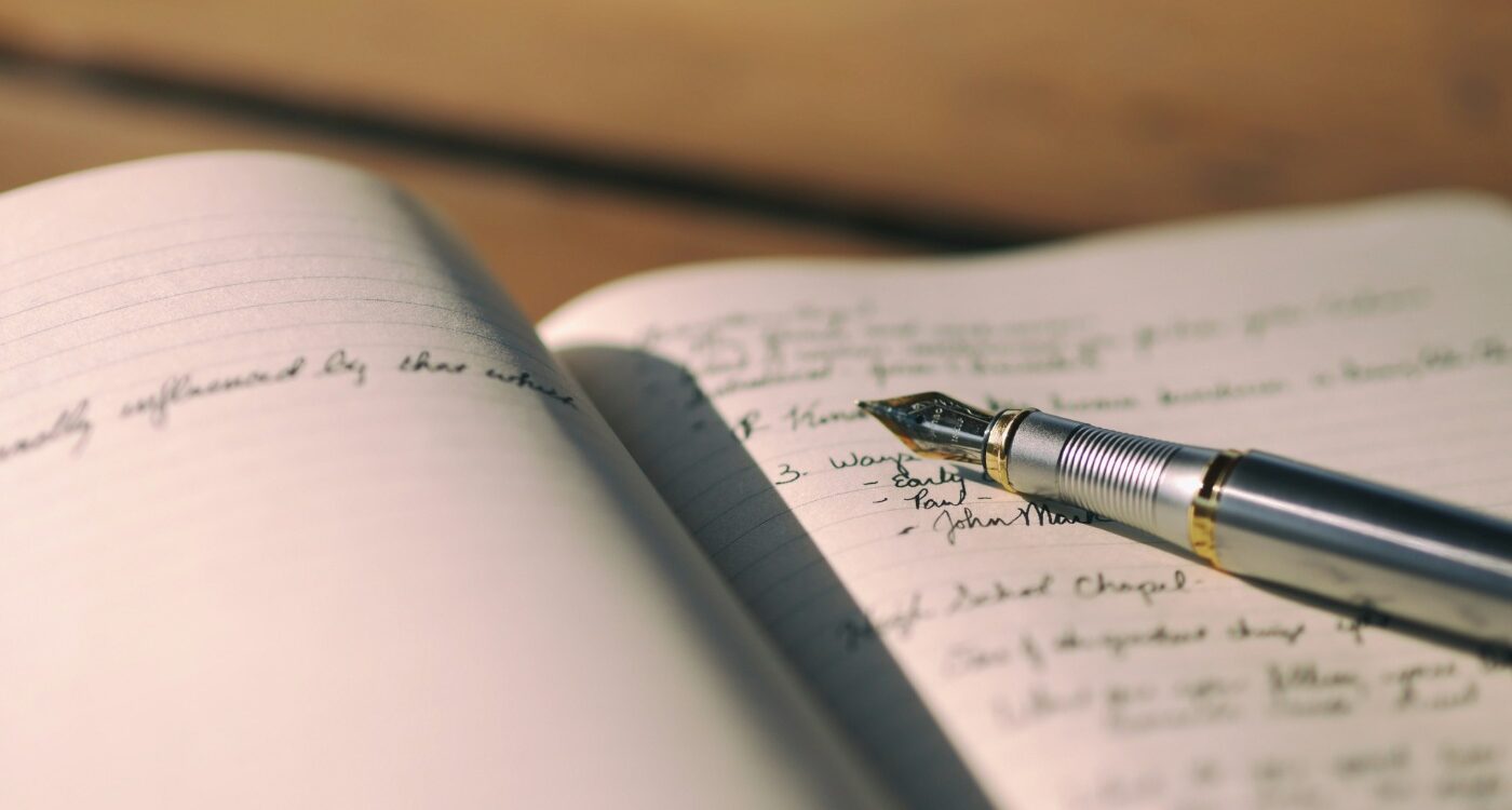 Pen resting on white lined notebook with writing in it - 6 Important Ways Writing Helps People Emotionally