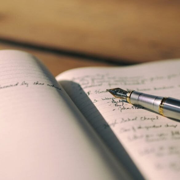 Pen resting on white lined notebook with writing in it - 6 Important Ways Writing Helps People Emotionally