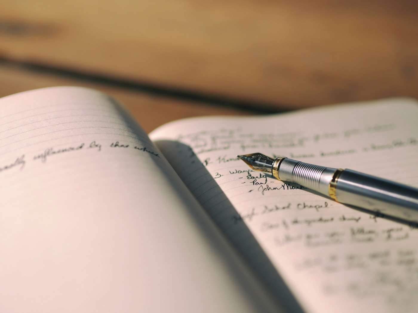WRITING FOR OUR LIVES: 6 meaningful reasons to express yourself with words 13 Pen resting on white lined notebook with writing in it - 6 Important Ways Writing Helps People Emotionally